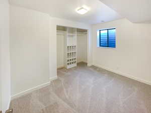 Unfurnished bedroom featuring a closet, light carpet, and baseboards