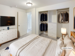 Bedroom featuring baseboards, light carpet, and a closet