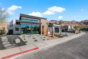 Contemporary home with driveway, a garage, a mountain view, and stucco siding