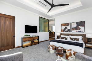 Carpeted bedroom featuring a raised ceiling, visible vents, ceiling fan, and baseboards