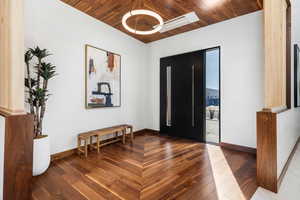 Foyer with wood ceiling, dark wood finished floors, and baseboards