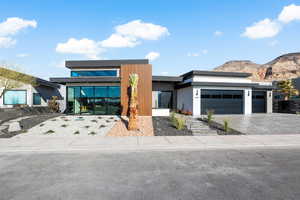 Modern home featuring a garage, decorative driveway, and a mountain view