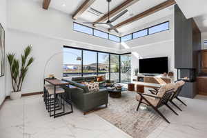 Living room with marble finish floor, a fireplace, and beamed ceiling