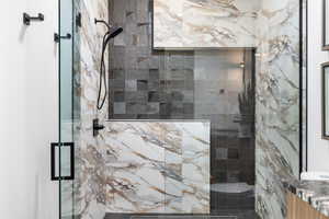 Full bathroom with a marble finish shower