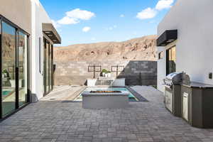 View of patio with a grill, a fire pit, area for grilling, and a mountain view