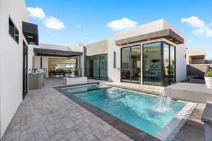 View of pool with a patio area and a pool with connected hot tub