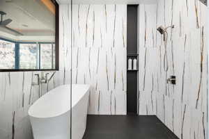 Bathroom featuring a freestanding bath and tile walls