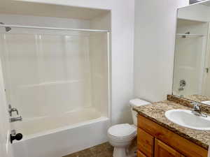 Full bathroom featuring  shower combination, tile patterned flooring, vanity, and toilet