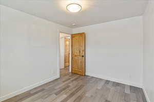 Unfurnished room with light wood-style flooring and baseboards