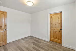 Unfurnished room with light wood finished floors and baseboards