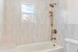 Full bathroom with washtub / shower combination and toilet