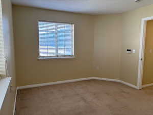 Master bedroom with light carpet and baseboards