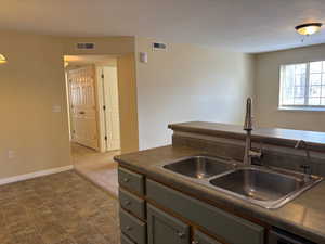 Kitchen featuring dark countertops and a sink