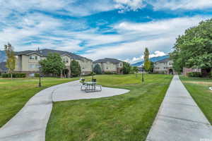 View of home's community featuring a residential view, a lawn, and a patio