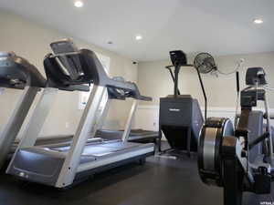 Workout area featuring recessed lighting and wainscoting