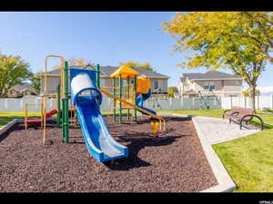 Community jungle gym with a yard and fence