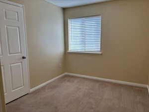 Bedroom featuring light-colored carpet and baseboards