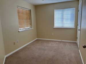 Bedroom  featuring light carpet and baseboards