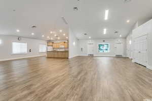 Unfurnished living room with light wood-style floors, visible vents, and baseboards