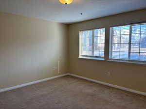 Empty room with carpet floors and baseboards