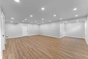 Basement featuring light wood-style flooring, baseboards, and recessed lighting