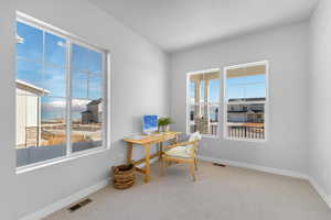 Office area featuring carpet floors, visible vents, and baseboards