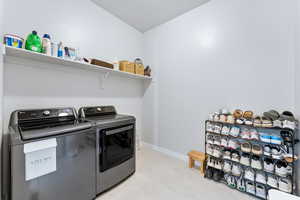 Washroom featuring laundry area, baseboards, and washer and clothes dryer