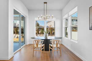 Dining space with a notable chandelier, baseboards, and wood finished floors