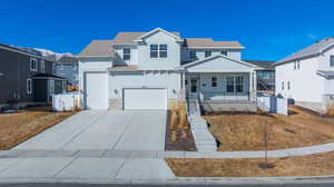 View of front of property with concrete driveway, stone siding, a residential view, fence, and a porch