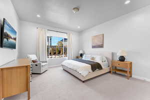 Bedroom with recessed lighting, light colored carpet, a textured ceiling, and baseboards