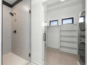 Full bath featuring a stall shower and stacked washer and clothes dryer