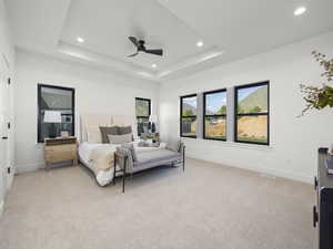 Bedroom featuring a tray ceiling, light carpet, baseboards, and recessed lighting