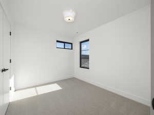 Unfurnished room with baseboards and light colored carpet