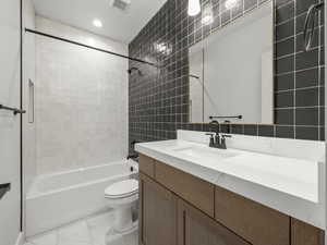 Full bath with toilet, vanity, visible vents, marble finish floor, and  shower combination