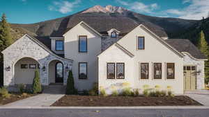 French country style house with stone siding, roof with shingles, and a mountain view