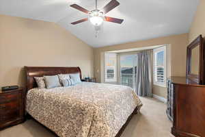 Bedroom with vaulted ceiling, ceiling fan, light carpet, and baseboards