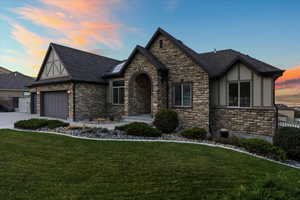 View of front of home with stucco siding, a shingled roof, concrete driveway, an attached garage, and a front lawn