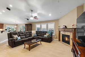 Living room with lofted ceiling, recessed lighting, baseboards, and a tile fireplace