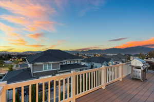 Wooden deck featuring a residential view, a mountain view, and area for grilling