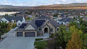 View of front of property featuring an attached garage, roof mounted solar panels, a mountain view, and fence
