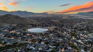 Aerial view at dusk featuring a water and mountain view and a residential view
