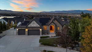 View of front facade featuring driveway, an attached garage, a gate, roof mounted solar panels, and a mountain view