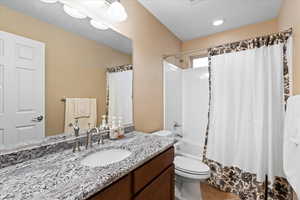 Full bath featuring vanity, shower / bath combination with curtain, and toilet