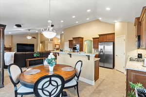 Dining space featuring light tile patterned floors, ceiling fan, high vaulted ceiling, and recessed lighting