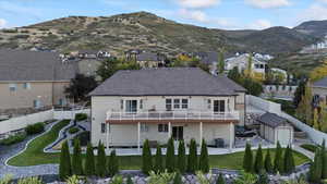 Rear view of property with an outbuilding, a storage unit, central AC, a mountain view, and a fenced backyard