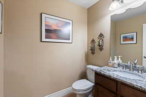 Bathroom featuring baseboards, vanity, and toilet