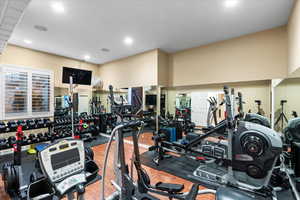 Exercise room with wood finished floors and recessed lighting