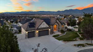 View of front of property featuring a mountain view, fence, driveway, a residential view, and a gate