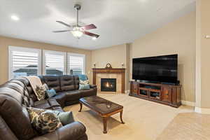 Living room with recessed lighting, baseboards, a tiled fireplace, ceiling fan, and light tile patterned flooring