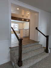 Staircase featuring recessed lighting, visible vents, wainscoting, a textured ceiling, and beamed ceiling